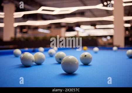 Boules blanches et boule de queue jaune sur table de billard bleue. Banque D'Images