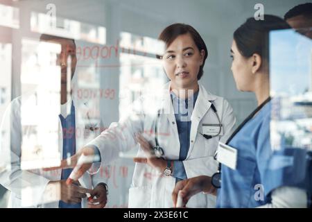 Médecin, les gens et l'équipe travaillent sur le panneau de verre pour la solution médicale, le brainstorming ou la résolution de problèmes en stage. Etudiant ou infirmier en santé parlant Banque D'Images