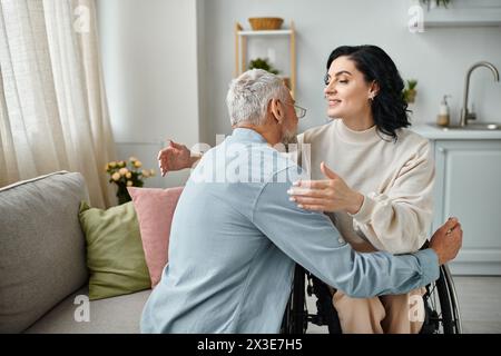 Une femme en fauteuil roulant embrasse tendrement son mari dans leur salon, montrant amour et soutien. Banque D'Images