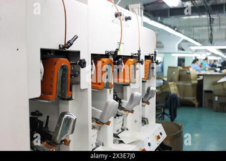 Machine pour produire des chaussures dans l'atelier de l'usine de chaussures, les gens hors de portée Banque D'Images