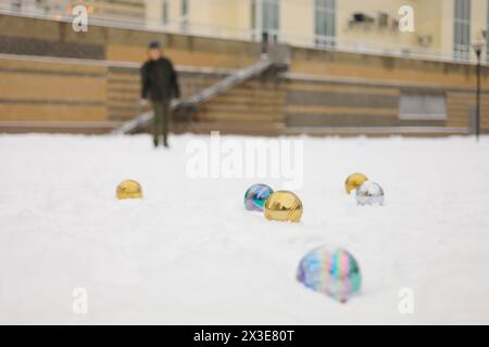 Six balles pour le jeu de pétanque sur la neige et garçon hors de portée en plein air le jour d'hiver Banque D'Images