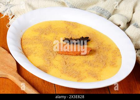 Curau, crème de maïs sucré et dessert typique de la cuisine brésilienne, placé dans un bol en céramique sur une table en bois. Gros plan Banque D'Images