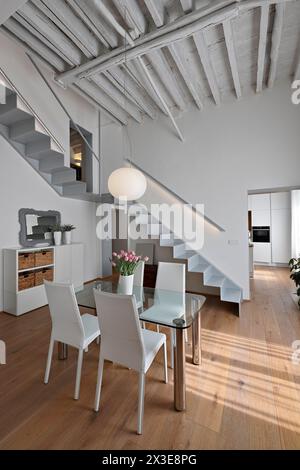 plan intérieur d'une salle à manger moderne au premier plan il y a une table à manger avec ses chaises Banque D'Images