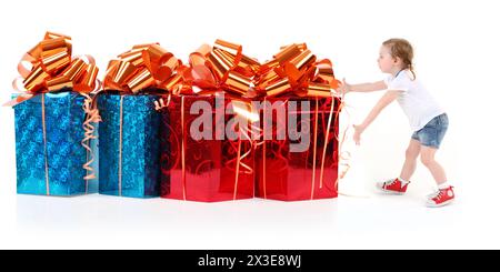 Petite fille et quatre boîtes cadeaux rouges et bleues sur blanc, collage Banque D'Images