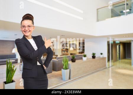 Femme d'affaires heureuse pouces vers le haut dans le salon au centre d'affaires moderne, collage Banque D'Images