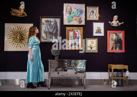 Londres, Angleterre, Royaume-Uni. 26 avril 2024. Un employé de la maison de vente aux enchères se tient à côté d'objets de la collection personnelle de Kenneth Partridge dans les salles de vente aux enchères de Bonham à Londres. Les collections personnelles de Kenneth Partridge, architecte d'intérieur des Beatles, et de l'écrivain et expert royal Hugo Vickers figurent parmi les points forts de la vente des collections Bonhams qui se déroulera du 29 au 30 avril à Bonhams Knightsbridge. La vente verra également la partie III de la vente des accessoires et costumes de la série Netflix The Crown, suite au succès de la vente principale chez Bonhams en février. (Crédit image : © Thom Banque D'Images