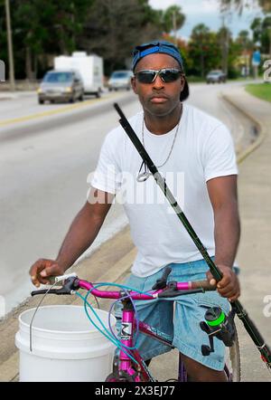 Homme afro-américain à vélo va pêcher à Saint Augustine, Floride, USA. Banque D'Images