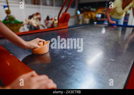 La famille joue au hockey pneumatique dans le centre de divertissement. Banque D'Images