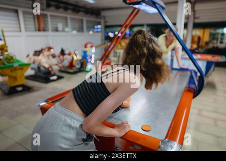 La famille joue au hockey pneumatique dans le centre de divertissement. Banque D'Images