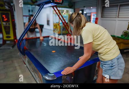 La famille joue au hockey pneumatique dans le centre de divertissement. Banque D'Images