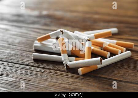 Arrêtez de fumer. Pile de cigarettes entières et cassées sur la table en bois, gros plan Banque D'Images