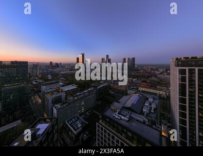 Cette image montre une vue panoramique en grand angle d'une ville baignée par la lumière chaude d'un coucher de soleil Banque D'Images