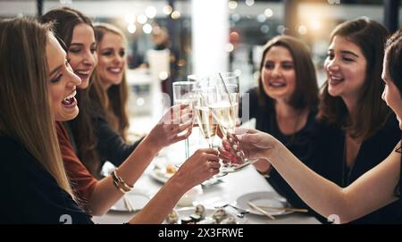 Groupe, femmes et champagne pour toast dans le restaurant pour dîner, célébration et sushi avec lumière de lentille. Amis, acclamations et heureux par table avec Banque D'Images