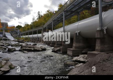 SHERBROOKE, QUÉBEC, CANADA - 10 octobre 2022 rivière Magog barrage de la centrale hydroélectrique Sherbrooke Abenakis. Grande conduite forcée blanche et passerelle Banque D'Images