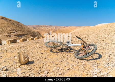 Vélo rouillé abandonné laissé dans le soleil brûlant dans le paysage désertique de montagne d'israël dans une zone arabe Banque D'Images