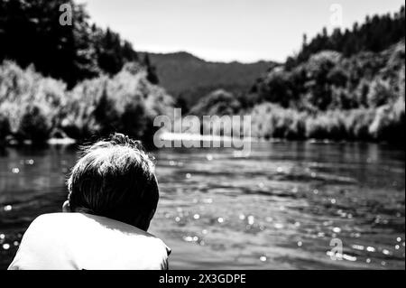 Focus sélectif sur un enfant descendant la sauvage et pittoresque Rogue River tout en portant un gilet de sauvetage Banque D'Images