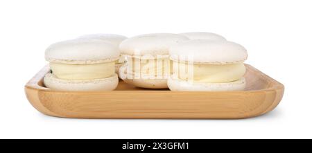 Délicieux macarons sucrés dans une assiette en bois isolé sur blanc Banque D'Images