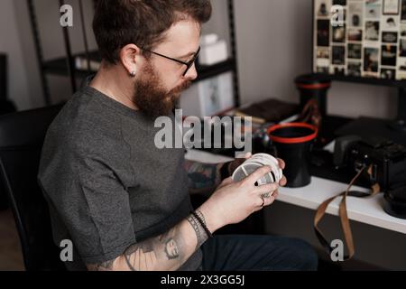 Photographe masculin analysant des négatifs de film en studio Banque D'Images