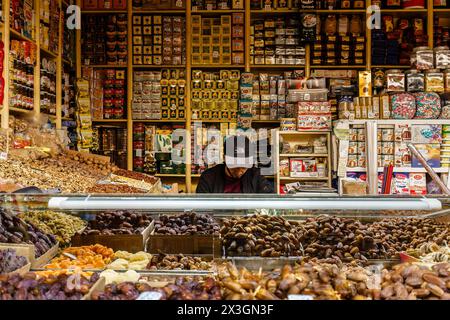 Tanger, Maroc. 6 février 2024 - Vendeur vendant des fruits secs et divers produits alimentaires dans un marché Banque D'Images