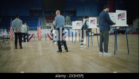 Votez ici signe sur le sol. File d'attente de citoyens américains multi-ethniques viennent voter dans les bureaux de vote. Jour des élections nationales aux États-Unis. Races politiques des candidats à la présidentielle américaine. Devoir civique. Banque D'Images