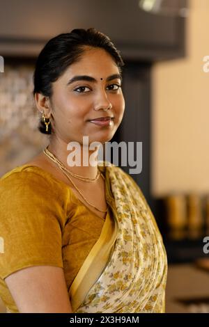 Jeune femme indienne dans le saree traditionnel, debout à la maison Banque D'Images