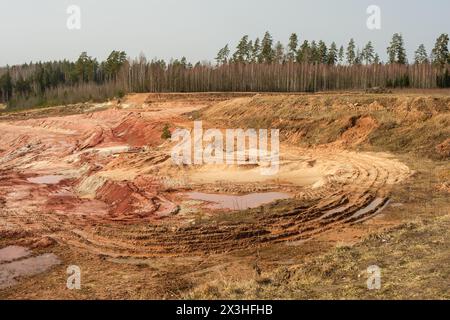 La beauté sauvage de la carrière de Lode en Lettonie invite à l'exploration, où chaque étape révèle une histoire écrite dans l'argile antique de la terre. Banque D'Images