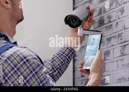 Ingénieurs ajustant le système de surveillance de sécurité avec technicien CCTV Banque D'Images