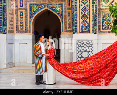 Samarkand, Ouzbékistan - 18 avril 2021 : mariée et marié dans des robes ouzbèkes traditionnelles à la ville antique du Registan, Samarkand ville en Ouzbékistan Banque D'Images