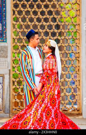 Samarkand, Ouzbékistan - 18 avril 2021 : mariée et marié dans des robes ouzbèkes traditionnelles à la ville antique du Registan, Samarkand ville en Ouzbékistan Banque D'Images