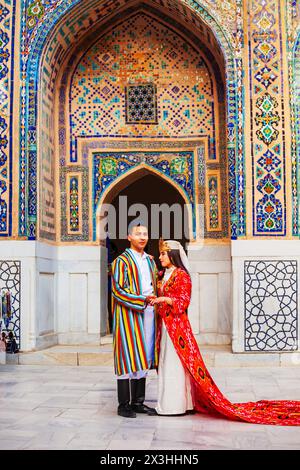 Samarkand, Ouzbékistan - 18 avril 2021 : mariée et marié dans des robes ouzbèkes traditionnelles à la ville antique du Registan, Samarkand ville en Ouzbékistan Banque D'Images