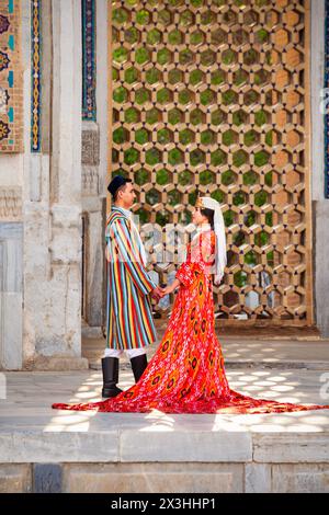 Samarkand, Ouzbékistan - 18 avril 2021 : mariée et marié dans des robes ouzbèkes traditionnelles à la ville antique du Registan, Samarkand ville en Ouzbékistan Banque D'Images