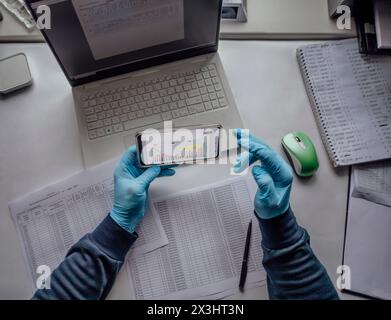 Intégration de la technologie dans la recherche en laboratoire. Bureau avec mains et ordinateur portable, pratiques scientifiques modernes. analyse numérique, avec un accent sur les données Banque D'Images