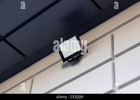 La lumière sur le côté du bâtiment affichant la lettre A est alimentée par l'électricité à travers le câblage électrique et reliée au plafond avec moi Banque D'Images