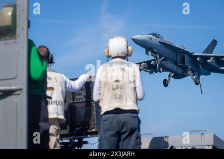 USS Harry S Truman, États-Unis. 24 avril 2024. Les marins de l'US Navy regardent un avion de chasse F/A-18E Super Hornet, attaché au Knighthawks of Strike Fighter Squadron 136 approcher pour un atterrissage arrêté sur le pont d'envol du porte-avions de classe Nimitz USS Harry S. Truman en cours d'opérations de routine, le 24 avril 2024, sur l'océan Atlantique. Crédit : MC2 Matthew Nass/U.S. Navy photo/Alamy Live News Banque D'Images