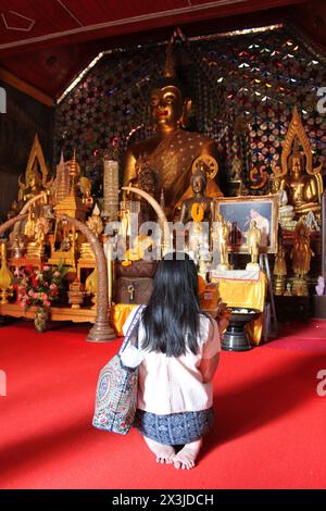 Chiang mai, Thaïlande, 14 avril 2015 : femme asiatique assise sur le sol priant à l'intérieur de Chiang mai Wat Doi Suthep, un temple bouddhiste (Wat). Banque D'Images