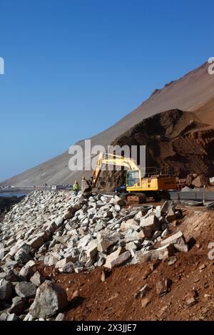 Une excavatrice Komatsu travaille sur un projet visant à améliorer l'accès routier et les installations de stationnement pour les grottes Cuevas de Anzota / Anzota, près d'Arica, Chili Banque D'Images