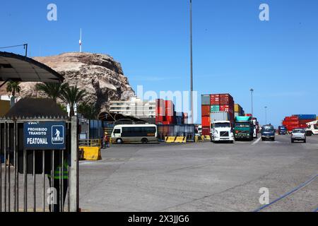 Camions et conteneurs empilés dans le port à conteneurs, promontoire El Morro sur le côté gauche, Arica, Chili Banque D'Images