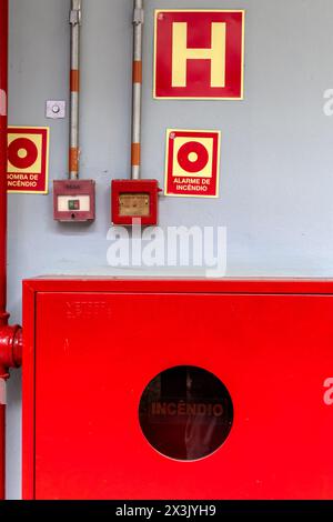 Détail d'une bouche d'incendie et d'une alarme pour éteindre et prévenir les incendies, avec des panneaux appropriés en portugais Banque D'Images