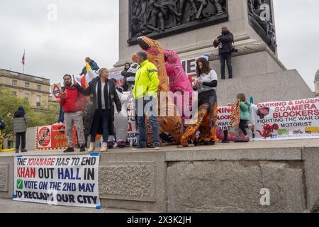 Londres, Royaume-Uni. Avril 27 2024 2023. Plusieurs centaines de personnes se tenaient au bord de la route à Trafalgar Square avec un bus, une voiture de pompiers et plusieurs habillés en dinosaures pour protester contre Sadiq Khan et l'ULEZ quelques jours avant l'élection du maire de Londres. Plusieurs candidats à la mairie étaient là, dont Piers Corbyn, mais des affiches appelaient les Londoniens à voter pour Susan Hall et à rejeter Khan qui a prolongé l'ULEZ, initialement prévue sous Boris Johnson, en août dernier pour réduire les décès et les maladies dus à la forte pollution atmosphérique à Londres. Peter Marshall/Alamy Live News Banque D'Images