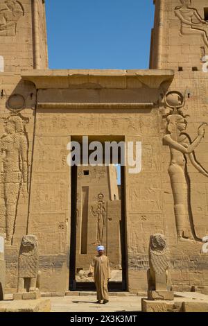 Homme local, le Premier pylône, Temple d'Isis, site classé au patrimoine mondial de l'UNESCO, Ile de Philae, Assouan, Egypte Banque D'Images