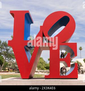 Pitbull et un bouledogue français posant dans une sculpture d'amour en plein air Banque D'Images