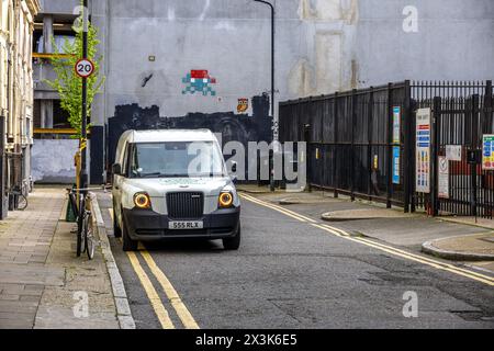 Camionnette électrique LEVC, basée sur le London Black Cab, sur fond d'art urbain. Banque D'Images