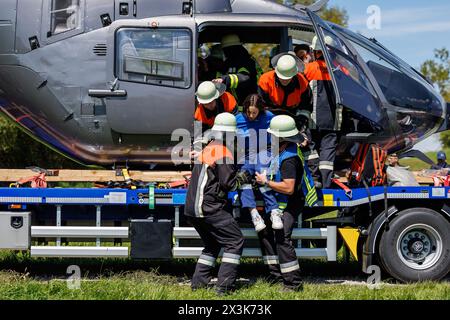 Ehingen, Allemagne. 27 avril 2024. Les pompiers secourent les passagers d'un hélicoptère atterri d'urgence lors de l'exercice de contrôle de la catastrophe « Flaming Spruce ». Il s'agissait d'un exercice de protection civile à grande échelle et autonome. Une propagation du feu a été simulée dynamiquement et des scénarios secondaires tels qu'un accident impliquant un pompier, l'évacuation d'un camp de tentes et l'atterrissage d'urgence d'un hélicoptère ont été pratiqués. Environ 600 membres du personnel d'urgence et environ 60 véhicules d'urgence y ont participé. Crédit : Daniel Karmann/dpa/Alamy Live News Banque D'Images