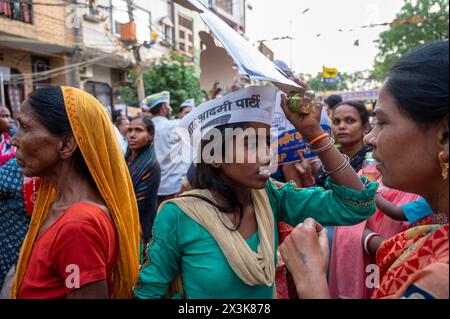 New Delhi, Inde. 27 avril 2024. Les travailleurs et sympathisants du parti AAM Aadmi participent à une tournée animée par la femme d'Arvind Kejriwal, Sunita Kejriwal, à Kalyan Puri, dans la circonscription d'East Delhi. AAM Aadmi Party (AAP) organise une tournée avant les élections de Lok Sabha. Le parti AAM Aadmi est un parti politique indien et est actuellement le parti au pouvoir dans l'État indien du Pendjab et le territoire de l'union de Delhi. Crédit : SOPA images Limited/Alamy Live News Banque D'Images