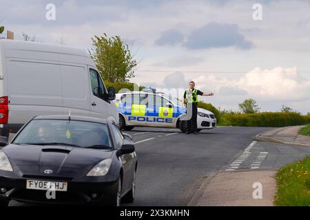 Un policier détourne la circulation d'un incident sur Wakefield Road à Swillington, Leeds, West Yorkshire, UK Banque D'Images