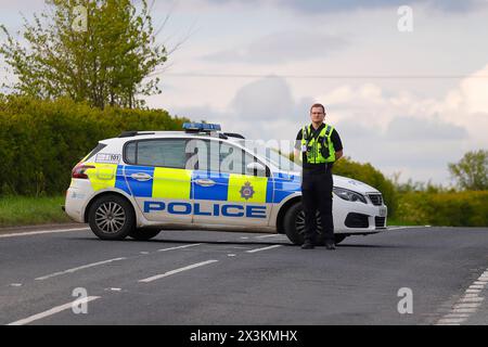 Un policier détourne la circulation d'un incident sur Wakefield Road à Swillington, Leeds, West Yorkshire, UK Banque D'Images