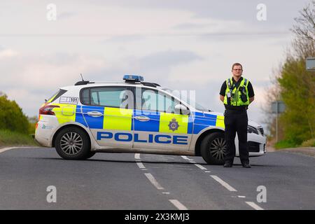 Un policier détourne la circulation d'un incident sur Wakefield Road à Swillington, Leeds, West Yorkshire, UK Banque D'Images