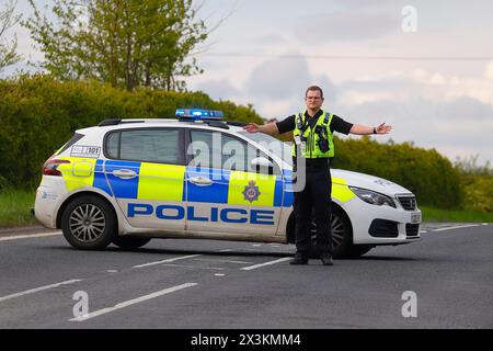 Un policier détourne la circulation d'un incident sur Wakefield Road à Swillington, Leeds, West Yorkshire, UK Banque D'Images