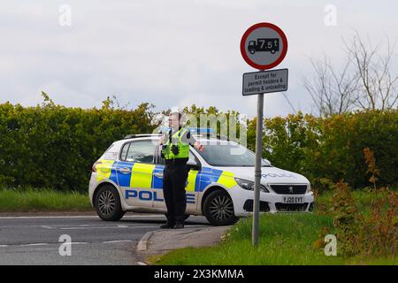 Un policier détourne la circulation d'un incident sur Wakefield Road à Swillington, Leeds, West Yorkshire, UK Banque D'Images