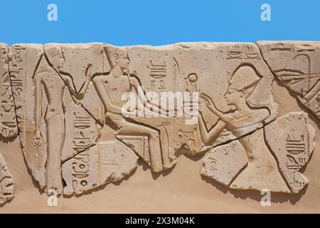 Relief représentant le pharaon égyptien Seti I faisant une offrande au Dieu Amon au temple mortuaire de Seti I sur la Cisjordanie de Louxor, en Égypte Banque D'Images